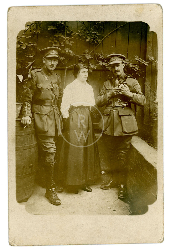 Harry Colebourn standing with woman and a solider holding small dog